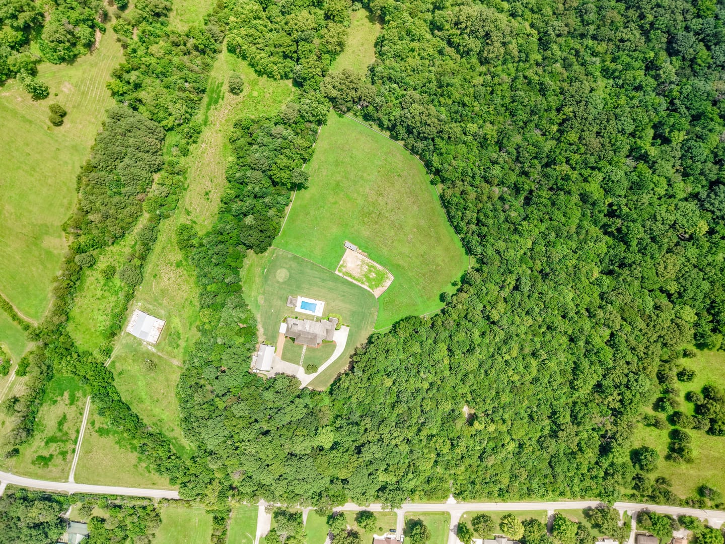 Overhead aerial view of the house, pasture and tree cover