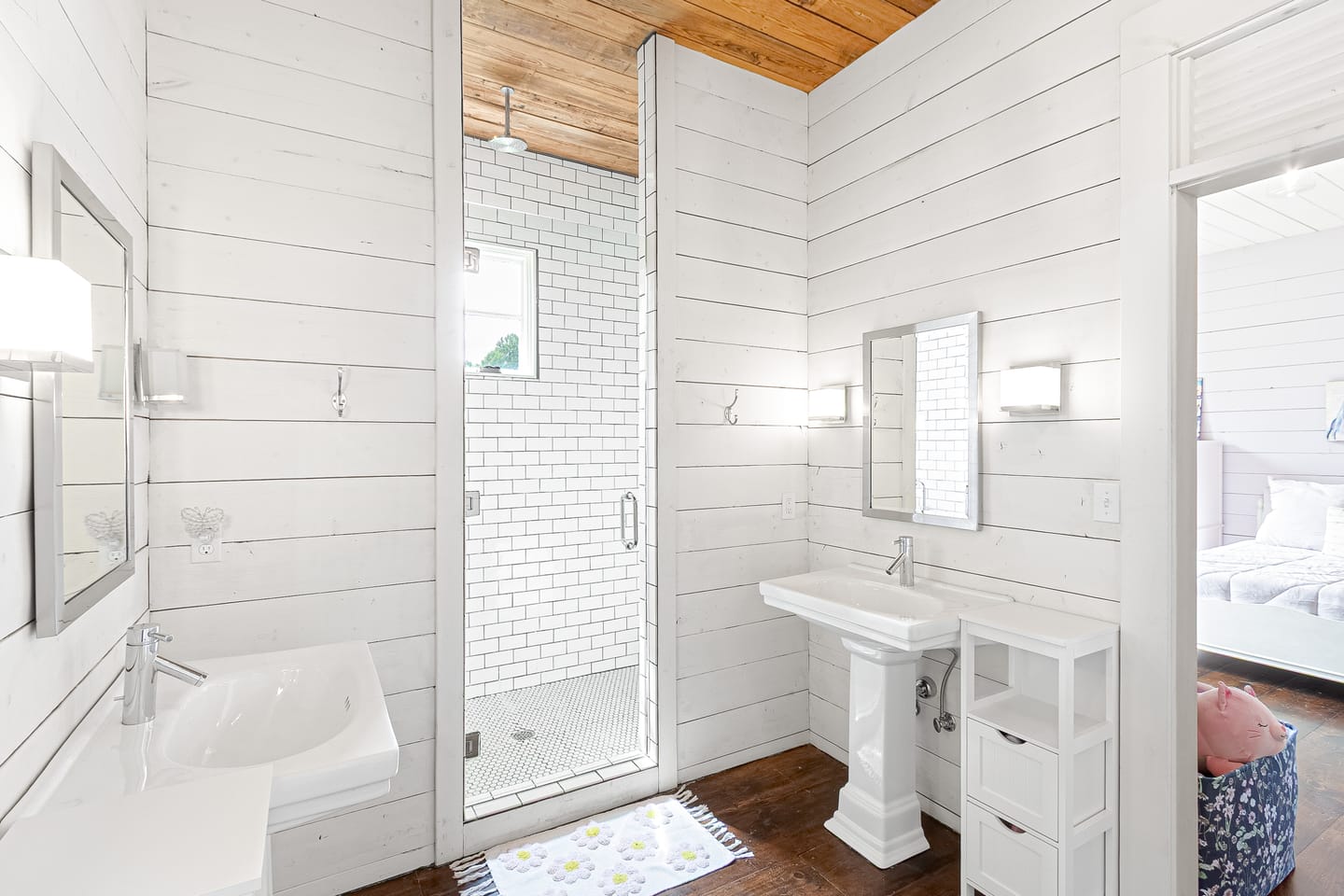 Bathroom with a pedestal sink and a subway tile shower