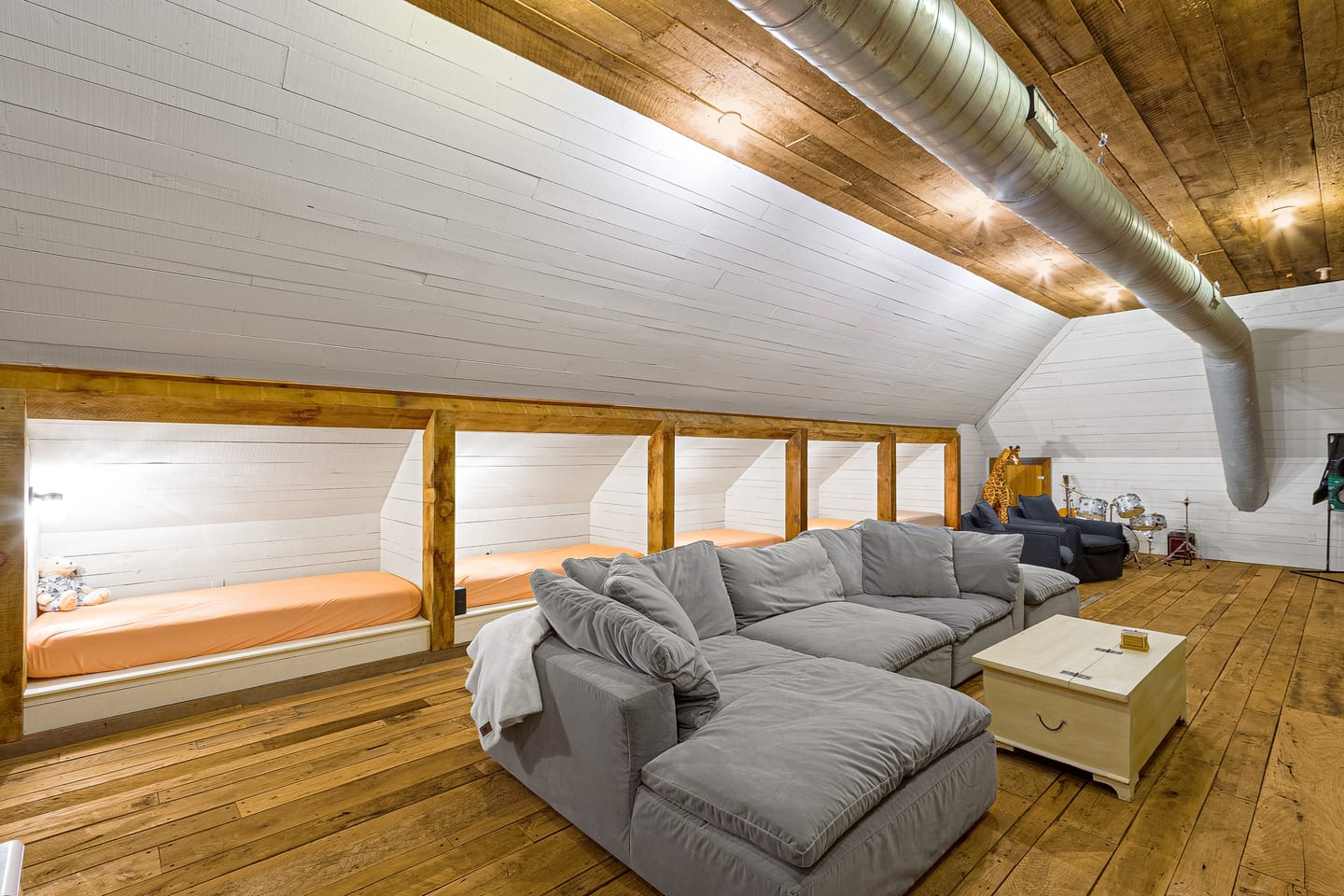 Bonus room with a sectional sofa and built-in bed nooks under the eaves