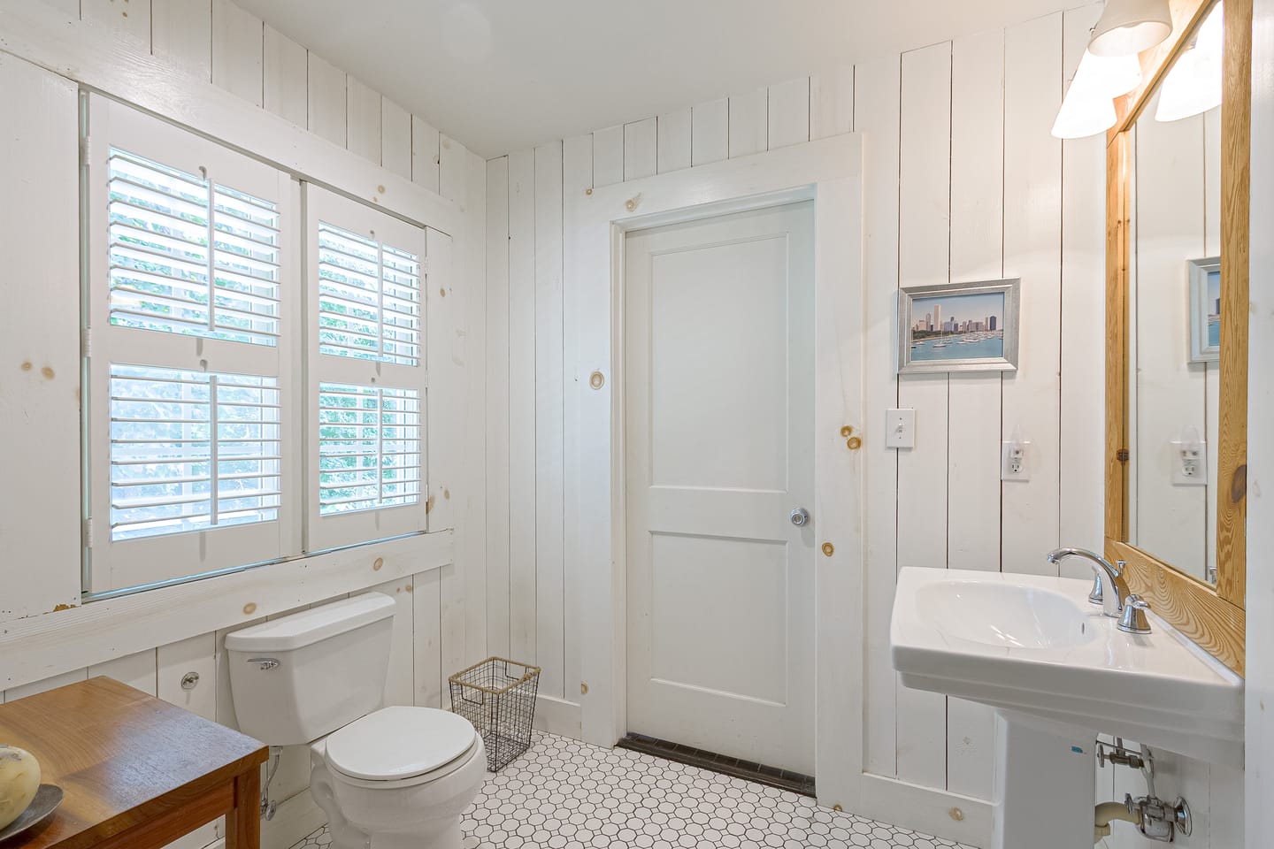 Carriage house bathroom with a pedestal sink and board-and-batten walls