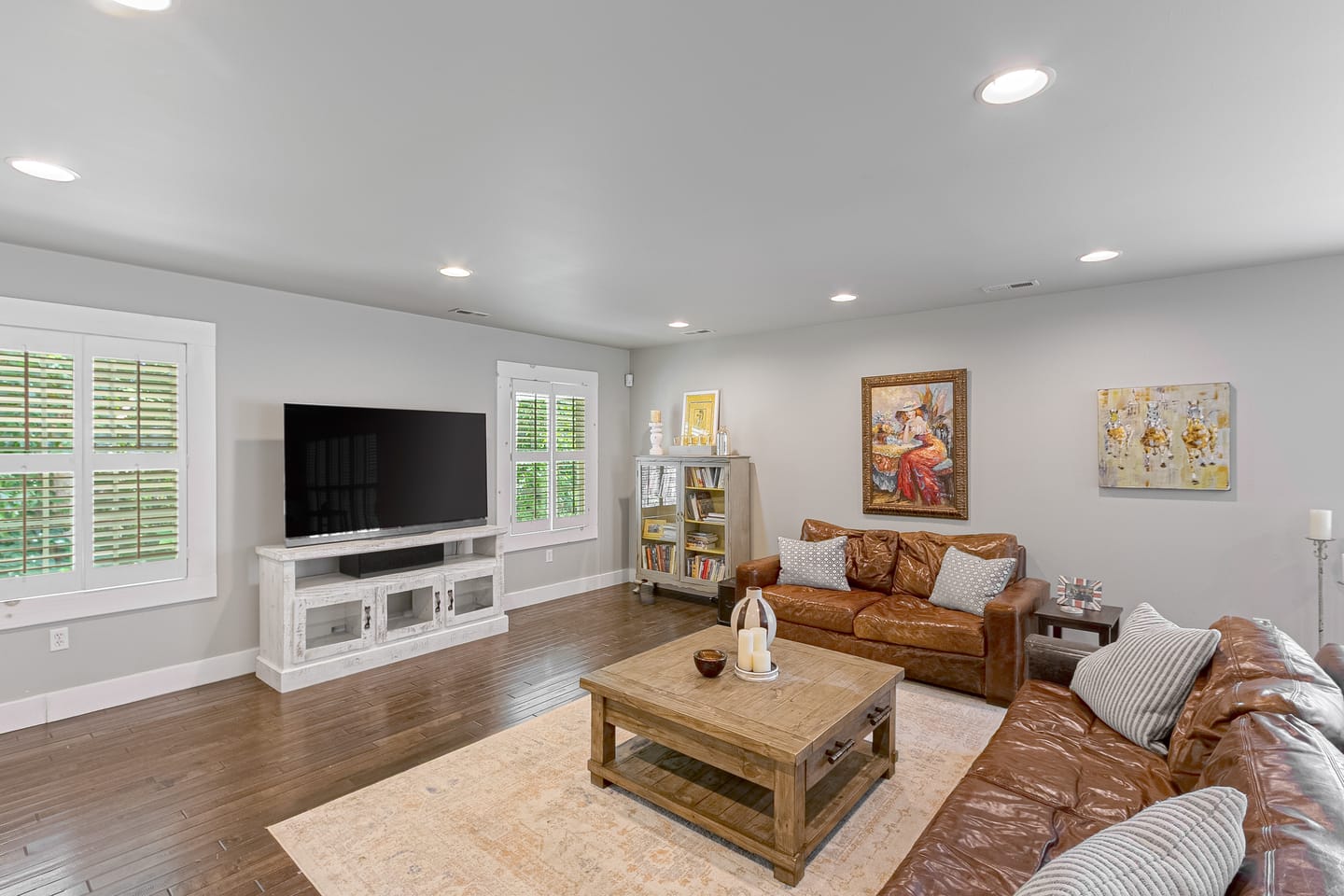 Carriage house living room with a leather sofa and plantation shutters