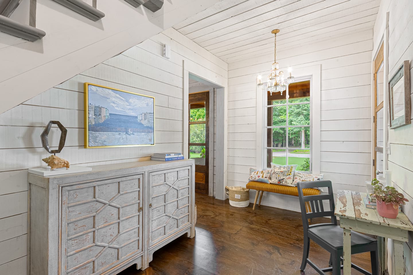 Entry hall with a chandelier, staircase and shiplap walls