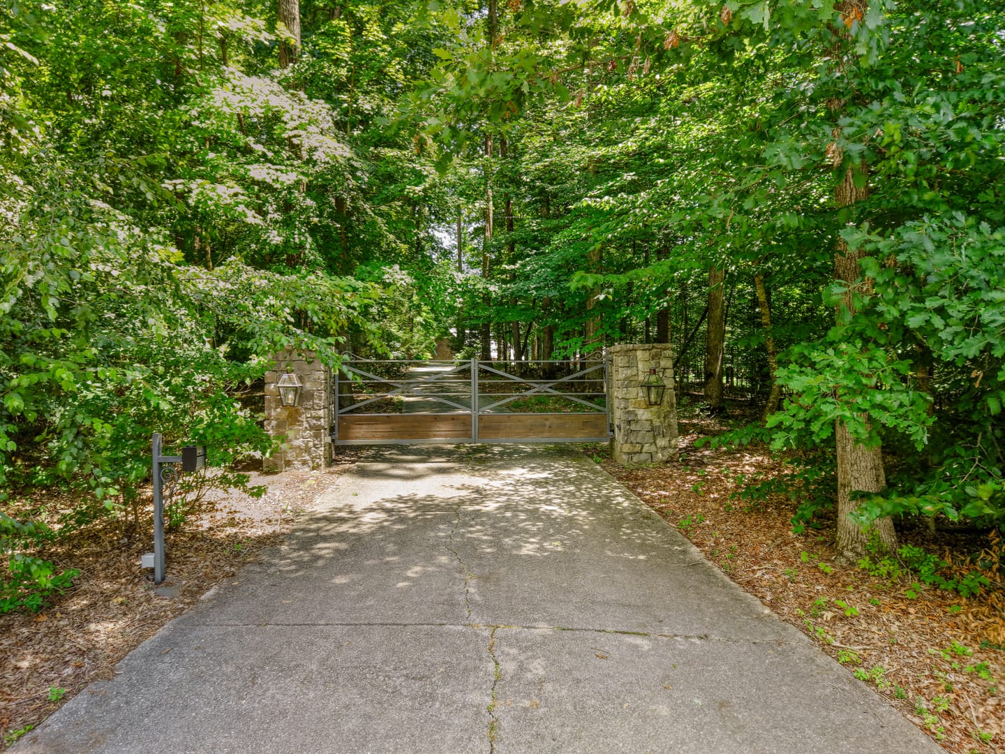 Wooden gate between stone pillars at the wooded entrance drive