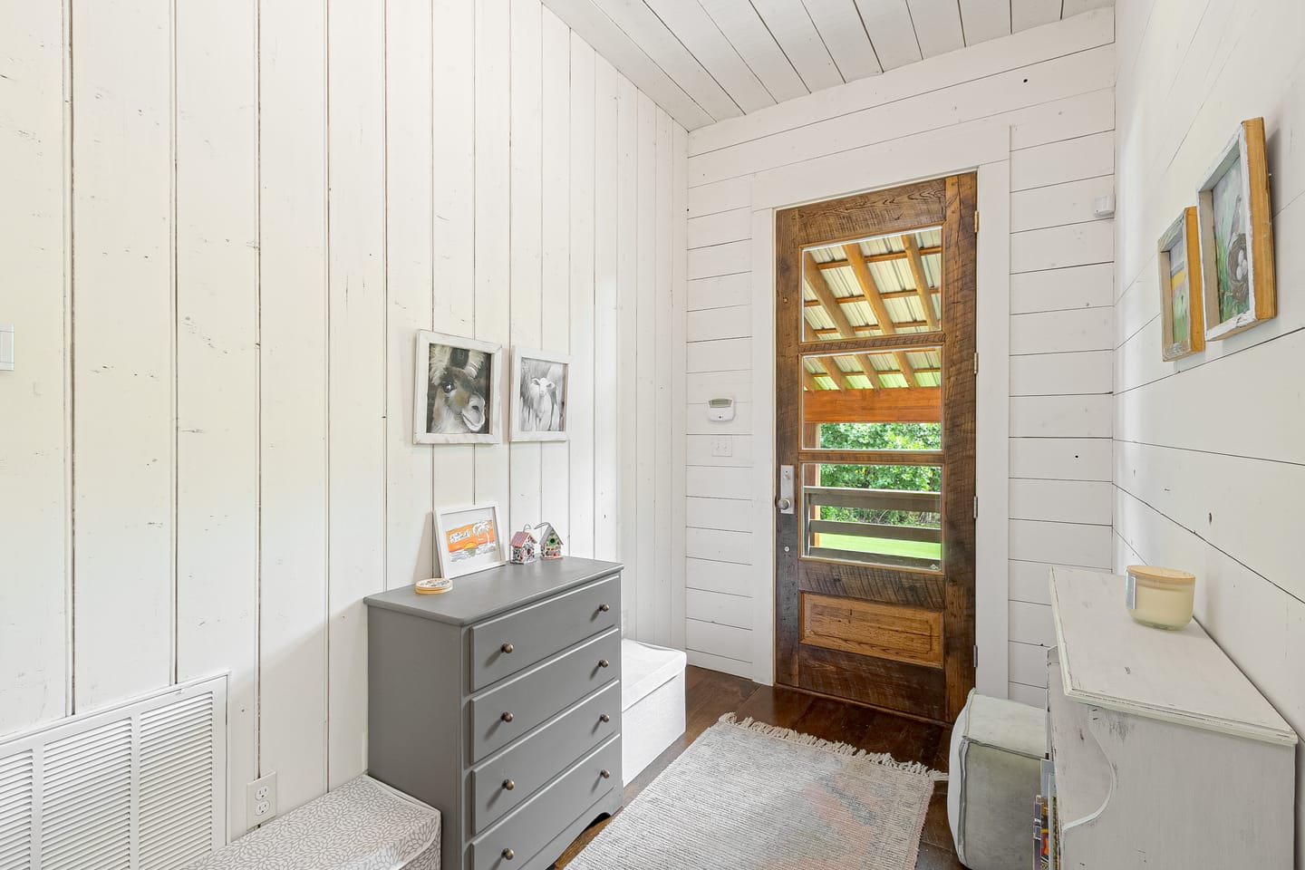 Hallway with an antique wood door and shiplap walls