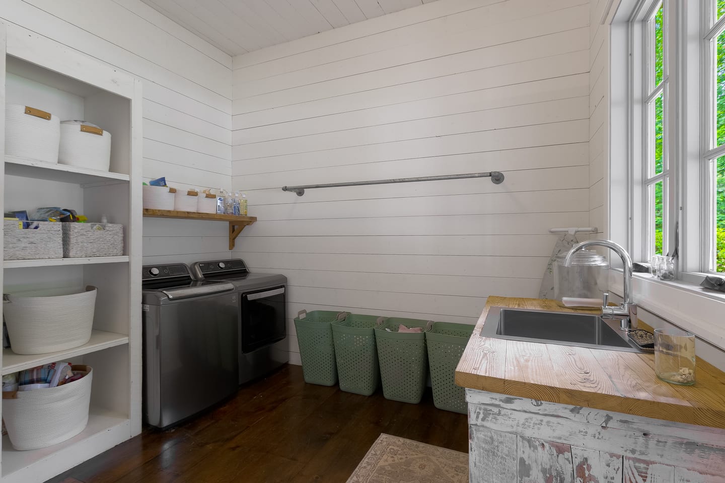 Laundry room with a utility sink, open shelving and a washer and dryer