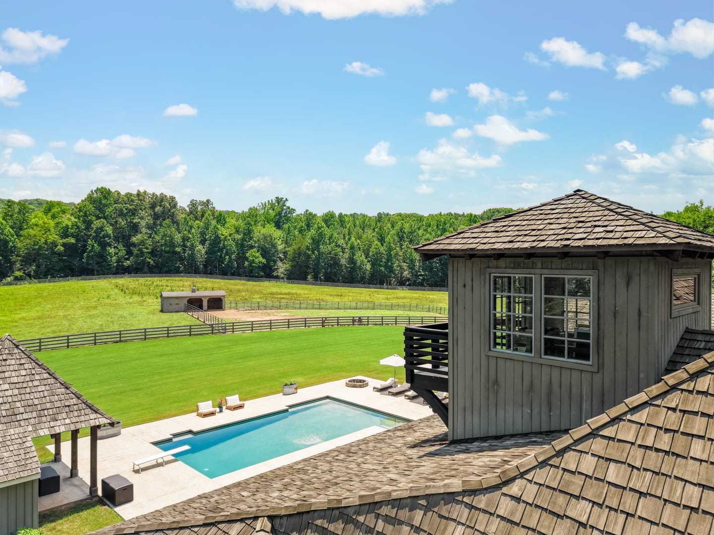 Rooftop lookout above the pool with the fenced pasture beyond