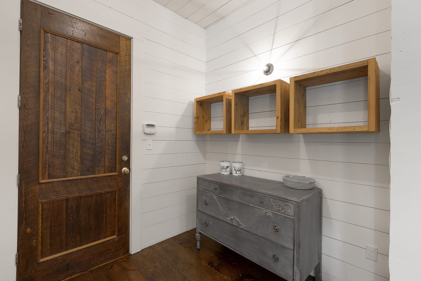 Mudroom with wood cubbies, a chest of drawers and an antique door