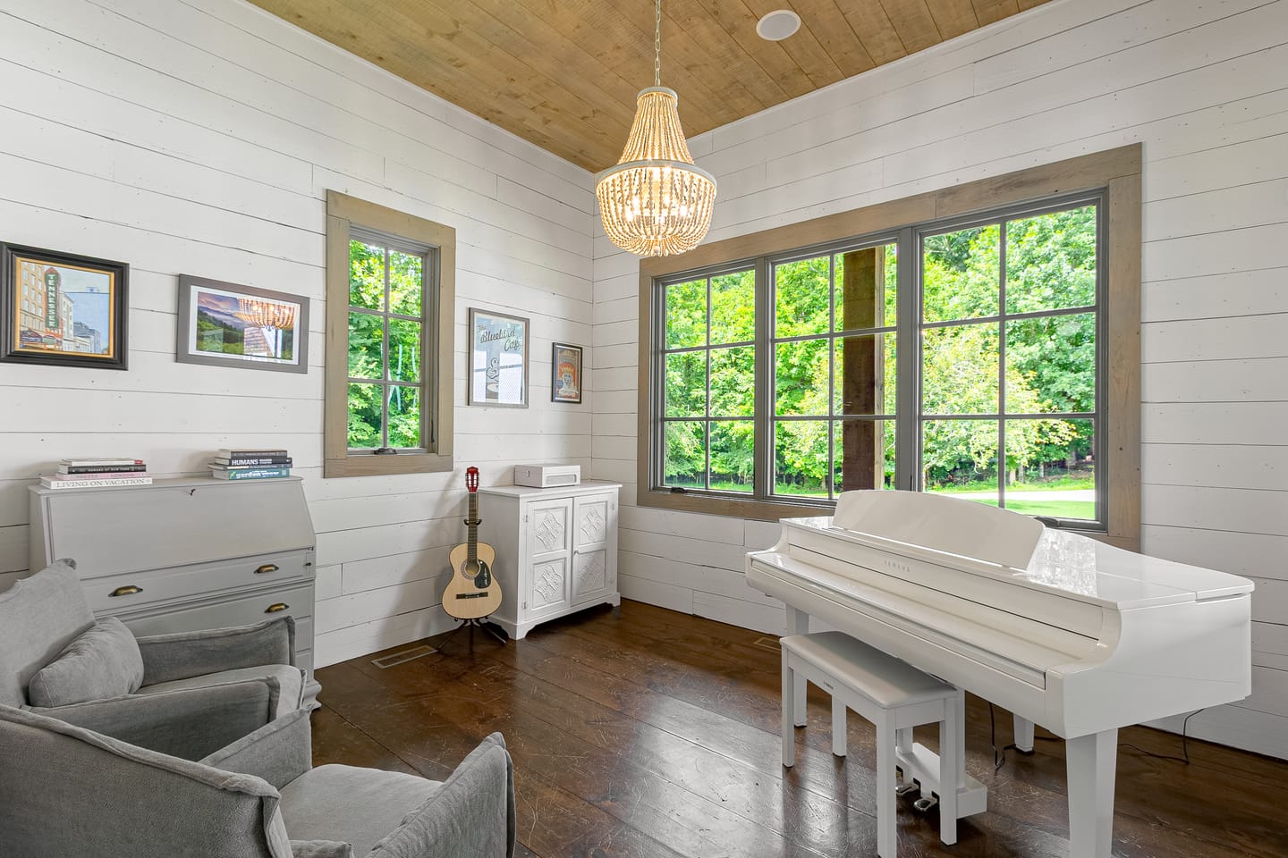 Bright room with a wall of windows, a piano and a writing desk