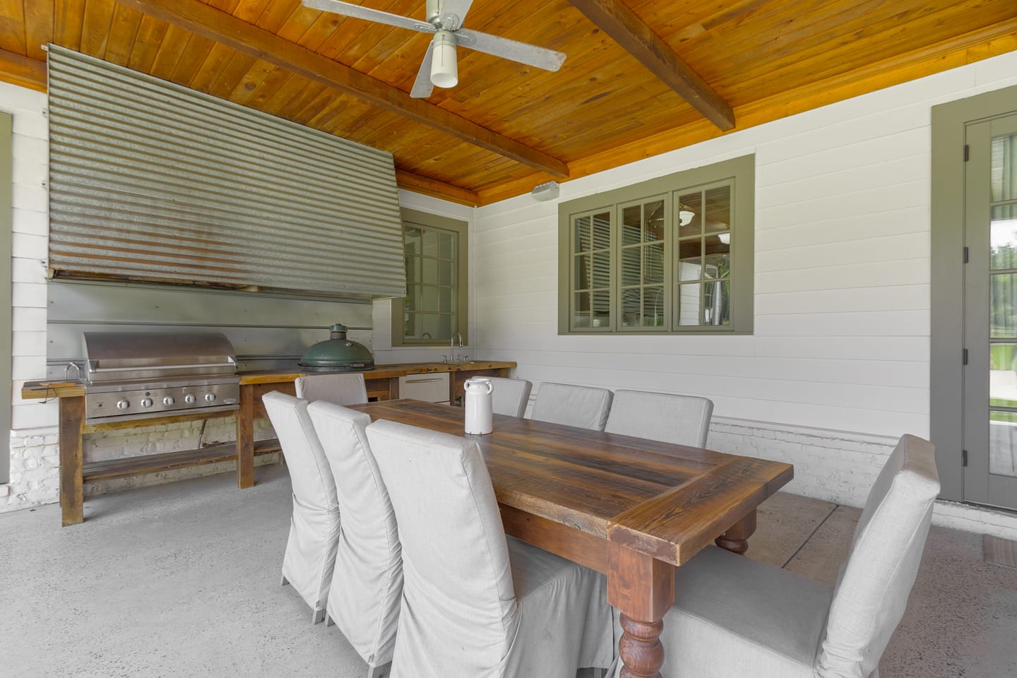 Outdoor kitchen with a built-in grill and a long dining table