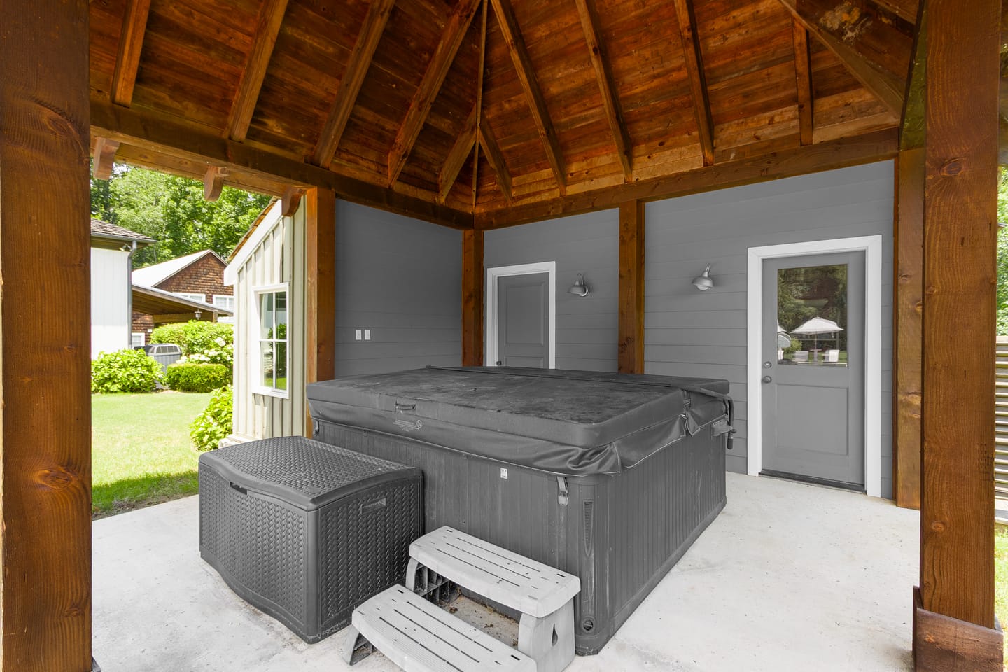 Pool house pavilion with a vaulted wood ceiling and a covered spa