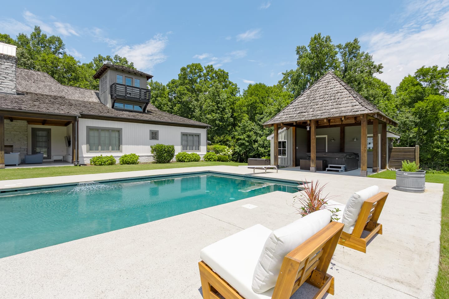Loungers beside the pool with the pool house pavilion