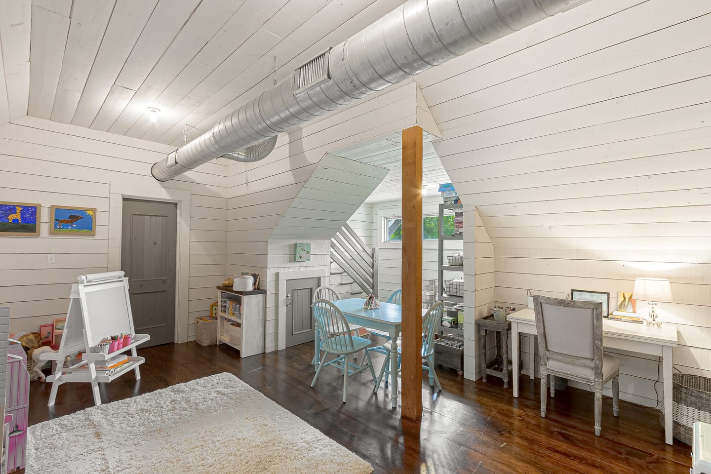 Upstairs room under the eaves with desks and a sitting area