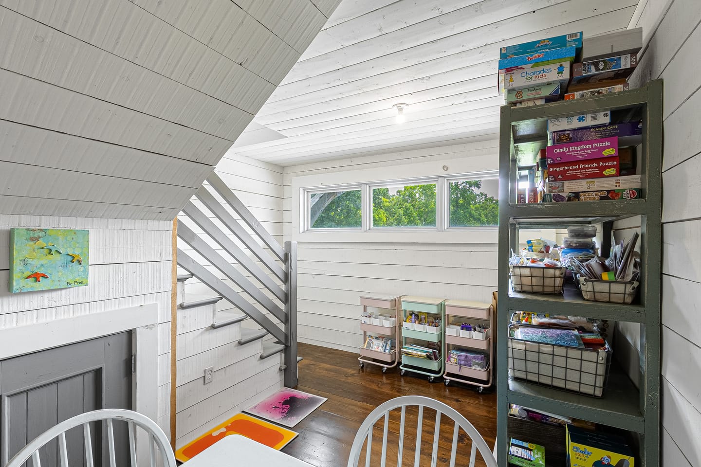 Upstairs room with a staircase, clerestory windows and shelving
