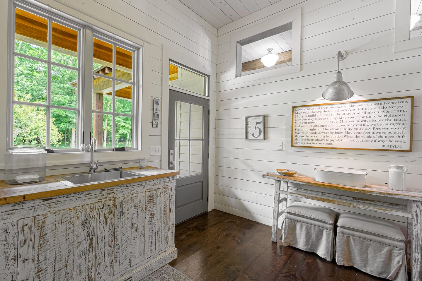 Utility room with a farmhouse sink, pendant light and window