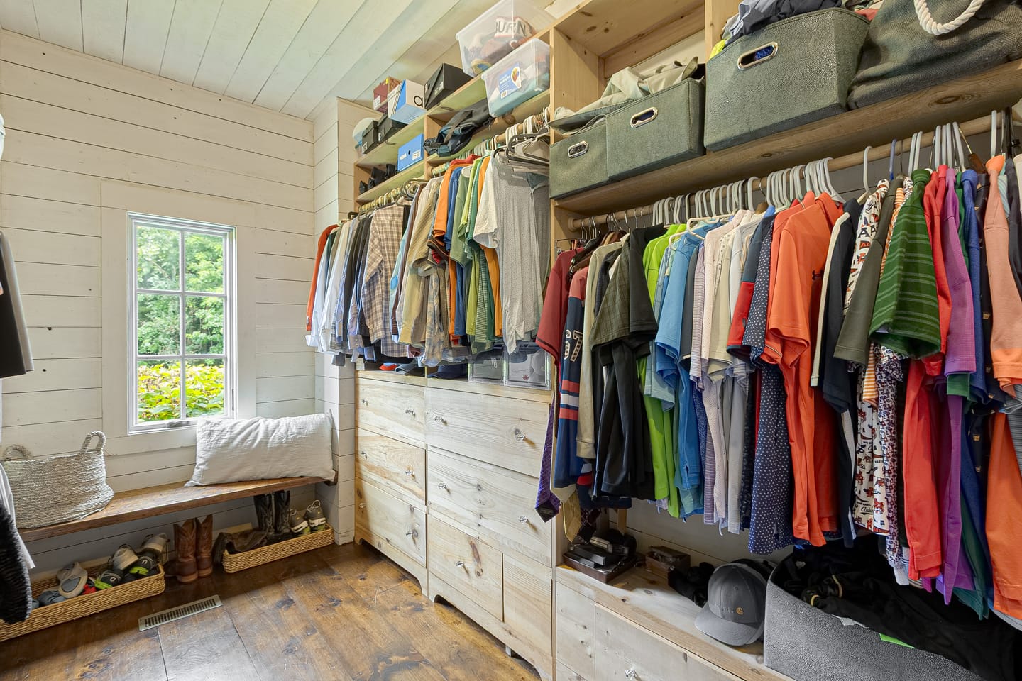 Walk-in closet with built-in drawers and a window seat
